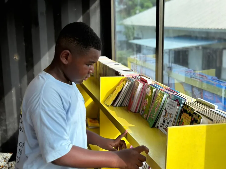 Un élève parcourt les rayonnages de la bibliothèque